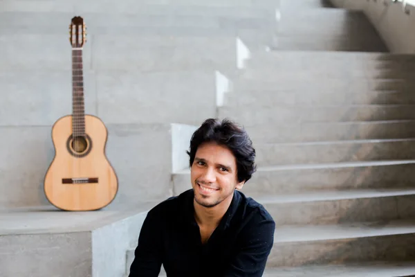 Retrato de Luis Leite com violão ao lado